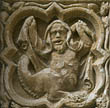 Panel 01:04 - Grotesque with bearded male head, hiding under his cloak